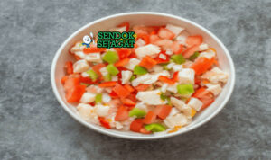 Conch salad khas Bahama siap saji: kerang conch iris kenyal dalam mangkuk, campur tomat dadu cerah, bawang merah, cabai rawit cincang, ketumbar segar, jeruk nipis peras, terlihat segar menggoda dengan warna-warni tropis