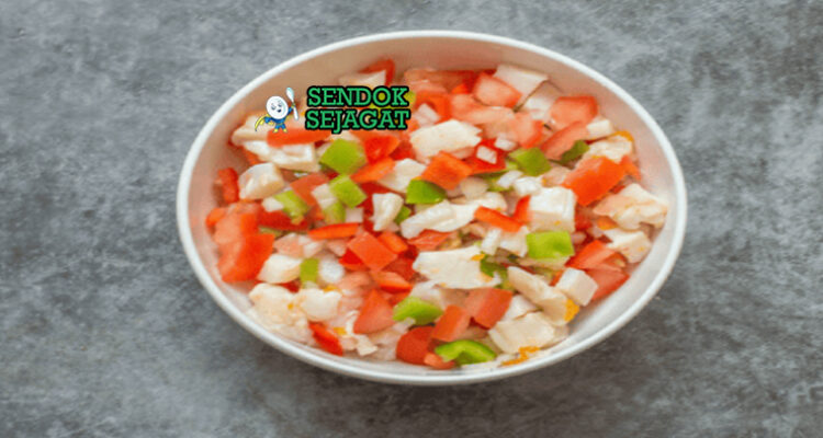 Conch salad khas Bahama siap saji: kerang conch iris kenyal dalam mangkuk, campur tomat dadu cerah, bawang merah, cabai rawit cincang, ketumbar segar, jeruk nipis peras, terlihat segar menggoda dengan warna-warni tropis