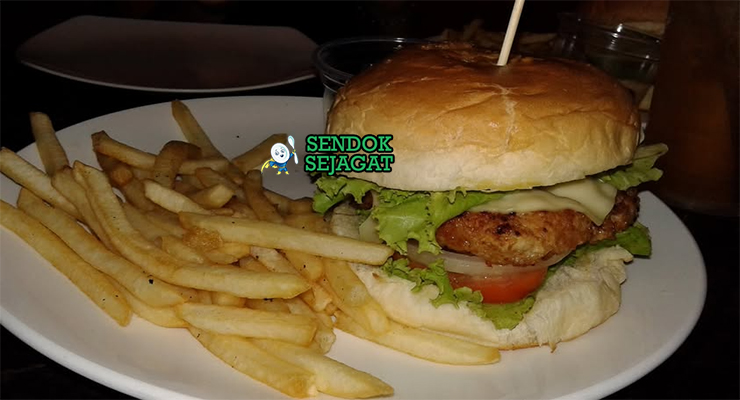 Burger crocodile khas Australia dengan patty daging buaya panggang juicy, alpukat halus, selada segar, irisan tomat, dan saus sweet chili di roti bun hangat