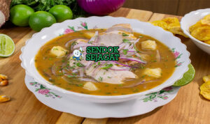 Mangkuk encebollado khas Ekuador berisi sup kaldu ikan bening kuning, potongan tuna lembut, yuca empuk, irisan bawang merah mentah, daun ketumbar segar, dan taburan cabai