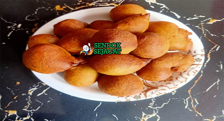 Tumpukan Kaimati khas Somalia yang renyah keemasan, direndam sirup madu mengkilap, tampak manis gurih menggugah selera