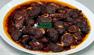 Piring Kala Bhuna khas Bangladesh dengan daging sapi empuk berbalut saus hitam pekat dari bawang karamel, tampak gurih dalam menggugah selera