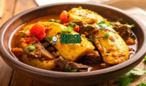 Mangkuk katogo khas Uganda dengan pisang raja hijau matooke lembut, potongan daging sapi empuk, wortel, tomat, dan taburan daun bawang dalam kuah kental gurih