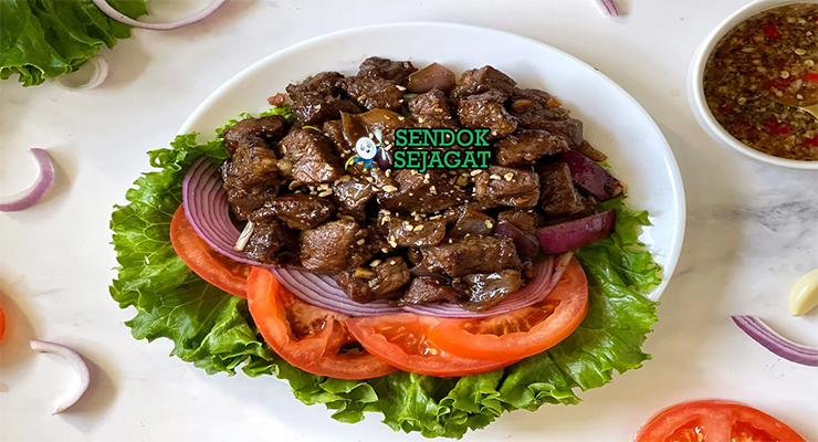 Piring lok lak khas Kamboja dengan potongan daging sapi berbalut saus hitam mengkilap, disajikan bersama selada, tomat, mentimun, bawang bombay dan nasi hangat