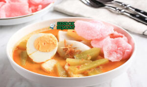 Lontong sayur Medan khas Indonesia siap saji: potongan lontong ketan pulen dalam mangkuk, disiram kuah santan kuning kental, labu siam empuk, telur rebus, tahu goreng, tauge segar, dan bawang goreng tabur, terlihat gurih hangat dengan uap mengepul