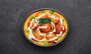 Malai Kofta Siap Saji dengan Saus Menggoda Hidangan Malai Kofta khas India dengan bola keju paneer goreng, saus creamy tomat, dan taburan kasuri methi, tampak lezat dan berwarna