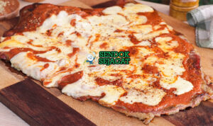 Irisan matambre a la pizza khas Argentina dengan daging gulung empuk, lapisan keju mozzarella meleleh, saus tomat merah, bawang bombay, tomat iris, dan taburan oregano kering