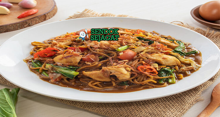 Mie godog khas Jawa siap saji: mangkuk mie kuning kenyal dengan kuah kaldu ayam manis gurih berwarna kecokelatan, ayam suwir lembut, telur rebus, kol iris, sawi hijau, tomat potong, bawang goreng tabur, daun bawang iris, dan kerupuk, terlihat hangat menggoda dengan uap mengepul