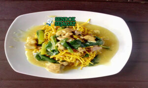 Mie kering khas Makassar siap saji: mie kuning kenyal terbalut bumbu kacang manis gurih berwarna cokelat kental, kikil sapi empuk, bakso urat, tauge segar, telur rebus, bawang goreng tabur, dan kerupuk emping, terlihat menggoda dengan warna cerah