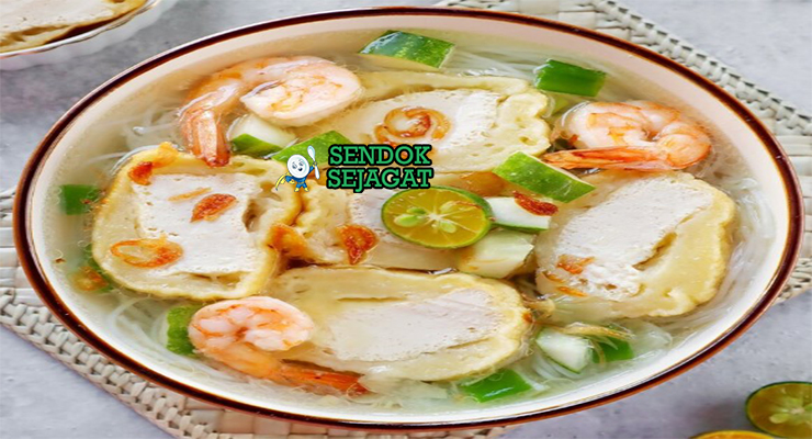 Mangkuk model khas Palembang dengan adonan ikan kenyal isi tahu, disiram kuah kaldu udang bening, taburan seledri, daun bawang, bawang goreng, dan soun