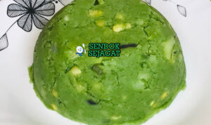 Mukimo khas Kenya siap saji: pure kentang lembut kental berwarna kuning pucat, campur kacang hijau manis, jagung manis kuning, bawang goreng tabur, disajikan dengan daging rebus dan sayur hijau, terlihat hangat menggoda di piring besar