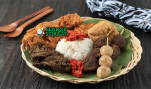 Piring Nasi Jamblang khas Cirebon dengan bungkus daun jati, cumi hitam blakutak, paru goreng, tahu goreng, sate telur puyuh, tampak harum gurih menggugah selera