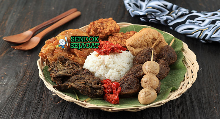 Piring Nasi Jamblang khas Cirebon dengan bungkus daun jati, cumi hitam blakutak, paru goreng, tahu goreng, sate telur puyuh, tampak harum gurih menggugah selera