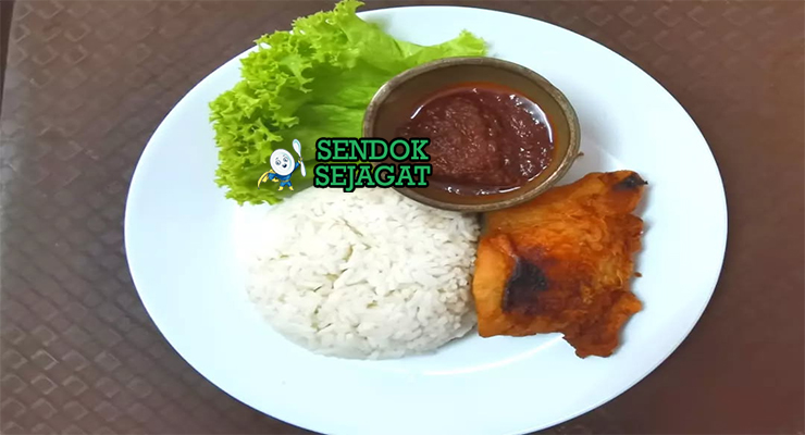 Porsi nasi katok khas Brunei dengan nasi putih hangat, potongan ayam goreng kecokelatan, telur mata sapi setengah matang, siraman sambal pedas manis, dan irisan timun segar