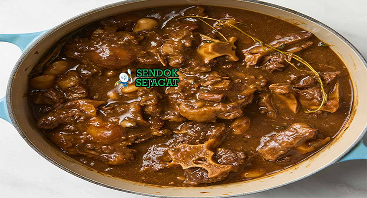 Oxtail stew khas Jamaica siap saji: potongan ekor sapi empuk lepas tulang dalam kuah kental cokelat gelap, butter beans, thyme, dan hint pedas Scotch bonnet, terlihat menggoda dengan uap hangat