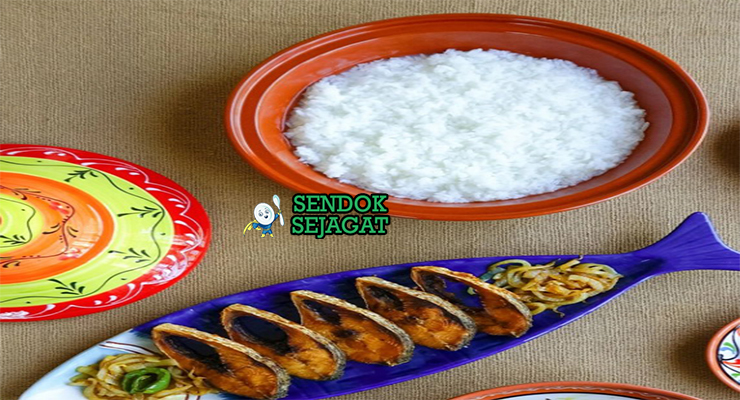 Mangkok Panta Ilish khas Bangladesh dengan nasi fermentasi dingin, ikan hilsa goreng renyah, bawang iris, cabai hijau, dan jeruk nipis, tampak segar gurih menggugah selera