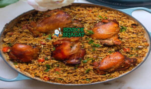 Pelau Hangat Khas Trinidad dengan Ayam, Kacang Pigeon dan Warna Cokelat Keemasan Pelau khas Trinidad siap saji: nasi satu panci berwarna cokelat keemasan, potongan ayam empuk, kacang pigeon creamy, cabai dan rempah Caribbean, terlihat gurih menggoda dengan uap hangat