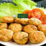 Tumpukan perkedel tahu khas Indonesia yang renyah keemasan, tampak gurih dengan irisan daun bawang, siap disantap