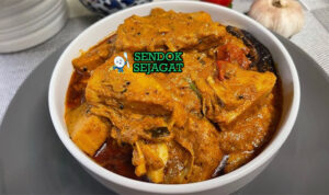 Mangkok Polos Curry khas Sri Lanka dengan nangka muda empuk, kuah santan kental rempah, cabai hijau, dan daun kari, tampak gurih pedas menggugah selera