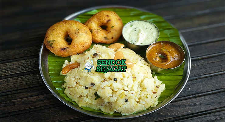 Mangkuk Ven Pongal khas India Selatan berisi bubur beras kacang hijau kental gurih, disiram ghee harum, taburan cashew goreng renyah dan daun kari segar, disajikan dengan sambar dan chutney