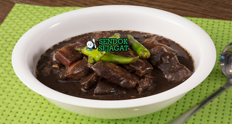 Pork dinuguan khas Filipina siap saji: sup darah babi hitam pekat gurih, potongan daging empuk, cabai hijau iris, dan kuah kental mengkilap, terlihat hangat menggoda dengan nasi putih
