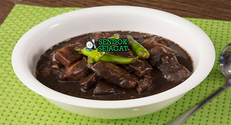 Pork dinuguan khas Filipina siap saji: sup darah babi hitam pekat gurih, potongan daging empuk, cabai hijau iris, dan kuah kental mengkilap, terlihat hangat menggoda dengan nasi putih