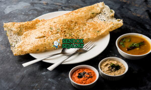 Lembaran Rava Dosa khas India yang tipis renyah berlubang, tampak gurih dengan taburan bawang dan cabai, siap disantap