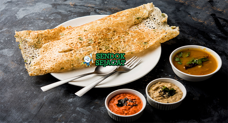 Lembaran Rava Dosa khas India yang tipis renyah berlubang, tampak gurih dengan taburan bawang dan cabai, siap disantap