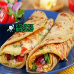 Rolex khas Uganda disajikan hangat: chapati lembut digulung telur dadar berisi kol iris, bawang, tomat, dan daun ketumbar, potong miring siap dimakan