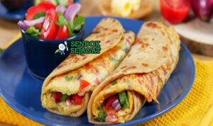 Rolex khas Uganda disajikan hangat: chapati lembut digulung telur dadar berisi kol iris, bawang, tomat, dan daun ketumbar, potong miring siap dimakan