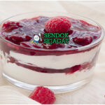 Rote Grütze Siap Saji Dingin dengan Krim Mangkok Rote Grütze khas Jerman dengan pudding berry merah lembut, potongan buah utuh, dituang krim segar, tampak segar dan menggugah selera