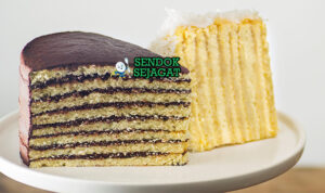 Potongan Smith Island Cake khas Maryland dengan 10 lapis kuning cake dan frosting cokelat tebal, tampak mewah dan gurih