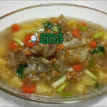 Mangkok sop urat khas Jakarta dengan potongan urat sapi empuk, sayur wortel kentang, daun bawang, dan taburan bawang goreng, tampak gurih dan segar