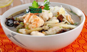 Mangkuk tekwan khas Palembang dengan kuah bening gurih, tekwan ikan kenyal, irisan bengkuang, jamur, dan taburan bawang goreng