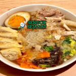 Mangkuk timlo khas Solo berisi kuah kaldu bening harum, suwiran ayam lembut, telur pindang kecokelatan, soun kenyal, wortel, jamur kuping, taburan bawang goreng dan daun bawang