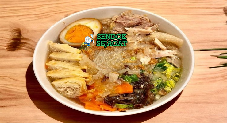 Mangkuk timlo khas Solo berisi kuah kaldu bening harum, suwiran ayam lembut, telur pindang kecokelatan, soun kenyal, wortel, jamur kuping, taburan bawang goreng dan daun bawang