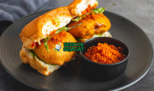 vada pav siap saji dengan chutney hijau Vada pav khas Mumbai dengan roti pav lembut, vada kentang goreng kriuk, dan saus chutney hijau segar