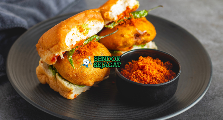 Vada pav khas Mumbai dengan roti pav lembut, vada kentang goreng kriuk, dan saus chutney hijau segar