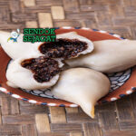 Yomari khas Nepal berbentuk bulan sabit dengan kulit tepung beras lembut, isian gula kelapa meleleh, tampak manis harum menggugah selera