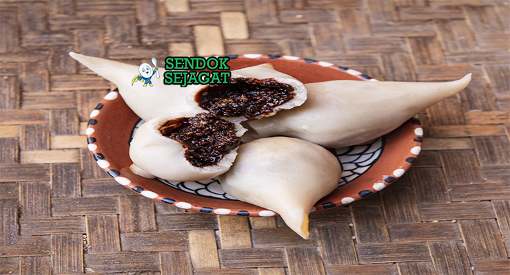 Yomari khas Nepal berbentuk bulan sabit dengan kulit tepung beras lembut, isian gula kelapa meleleh, tampak manis harum menggugah selera
