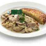 Piring Zürcher Geschnetzeltes khas Swiss dengan daging sapi iris empuk, saus krim jamur kental, tampak gurih creamy menggugah selera