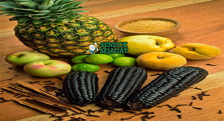 Bahan-bahan resep Chicha Morada termasuk jagung ungu kering, nanas, apel, kayu manis, cengkeh, jahe, gula pasir, dan jeruk nipis siap direbus