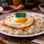 Arroz con Huevo Frito khas Kuba dengan nasi putih pulen dan telur mata sapi kuning lumer di atasnya, disajikan hangat di piring sederhana dengan pinggiran crispy