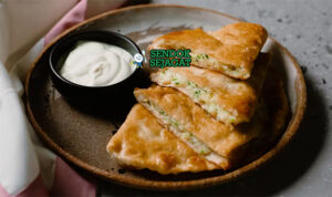 Bolani khas Afghanistan berbentuk setengah bulan renyah, isi kentang daun bawang gurih, tampak hangat menggugah selera