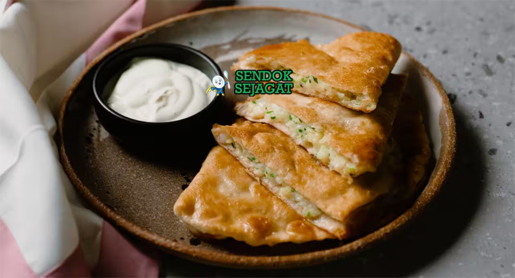 Bolani khas Afghanistan berbentuk setengah bulan renyah, isi kentang daun bawang gurih, tampak hangat menggugah selera