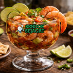 Coctel de Camarón khas Meksiko dengan camarón juicy di gelas tinggi, saus tomat merah segar, alpukat dan cilantro, tampak segar menggugah selera