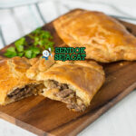 Cornish Pasty khas Cornwall berbentuk setengah bulan renyah keemasan, isi daging sapi kentang swede empuk, tampak gurih hangat menggugah selera