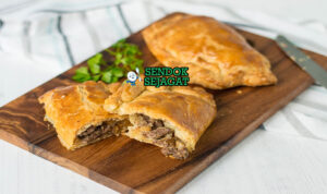 Cornish Pasty khas Cornwall berbentuk setengah bulan renyah keemasan, isi daging sapi kentang swede empuk, tampak gurih hangat menggugah selera