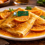 Crêpes Suzette khas Prancis dengan crêpes tipis lembut, saus jeruk karamel, flambé, tampak manis menggugah selera