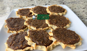 Gizzada Siap Nikmati Hangat Gizzada khas Jamaika berbentuk setengah bulan renyah, isi kelapa parut manis gurih mengalir, tampak manis tropis menggugah selera